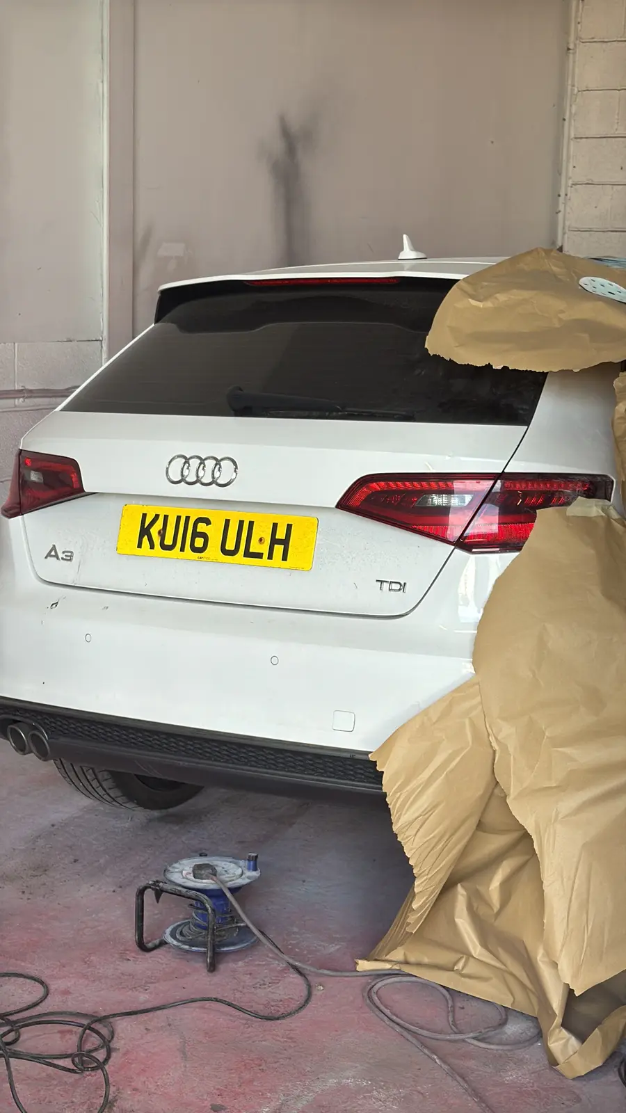 Audi A3 masked in the paint booth during rear-quarter preparation